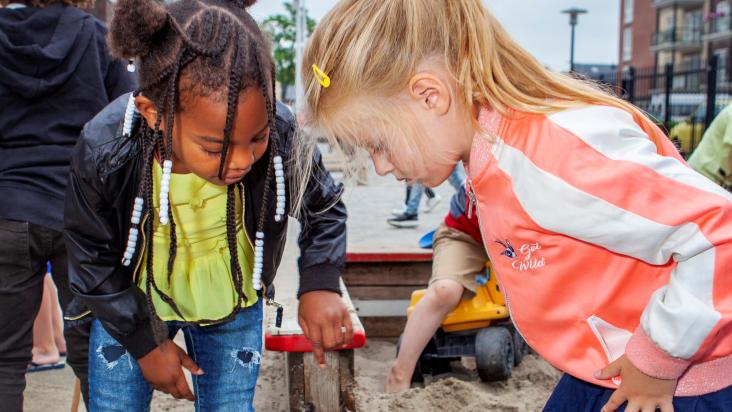 Meisjes spelen met zand