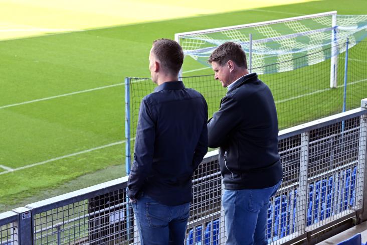 Twee personen bij een voetbalveld