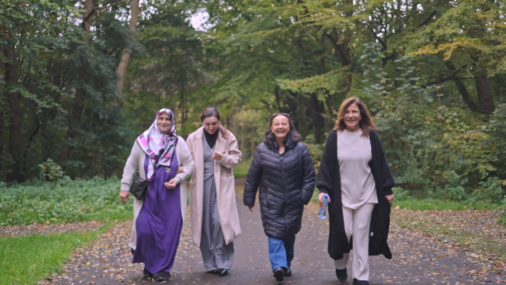 Vier Turkse vrouwen lopen door het park, op weg naar dagactiviteiten om de hoek voor vergeetachtige buurtbewoners.