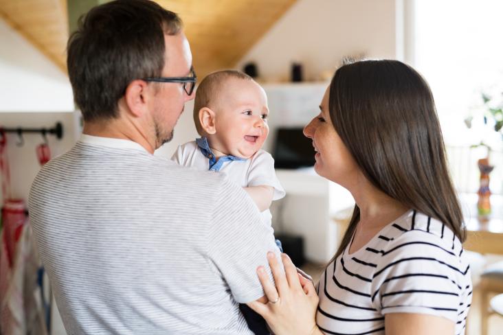 Man met baby op arm en vrouw die baby aankijkt