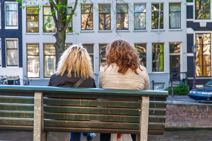 2 vrouwen zittend op een bankje aan de gracht