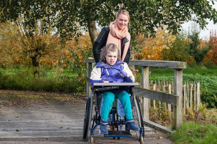 meisje in rolstoel met verstandelijke beperking met vrouw erachter