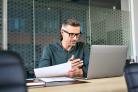 Man beoordeeld subsidieaanvraag achter laptop