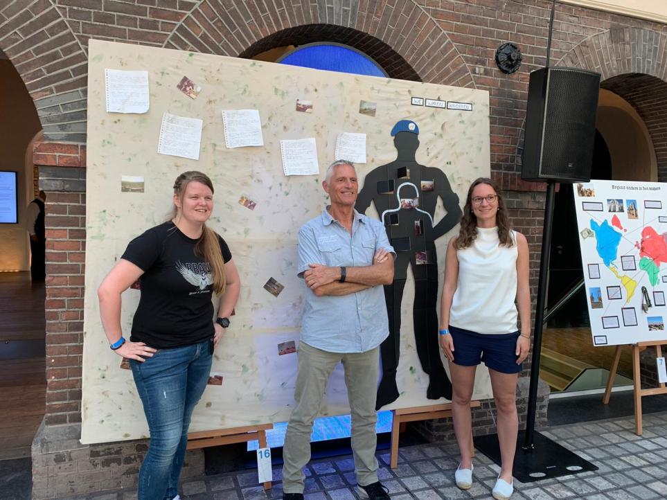 Jongeren en veteraan bij kunstwerk