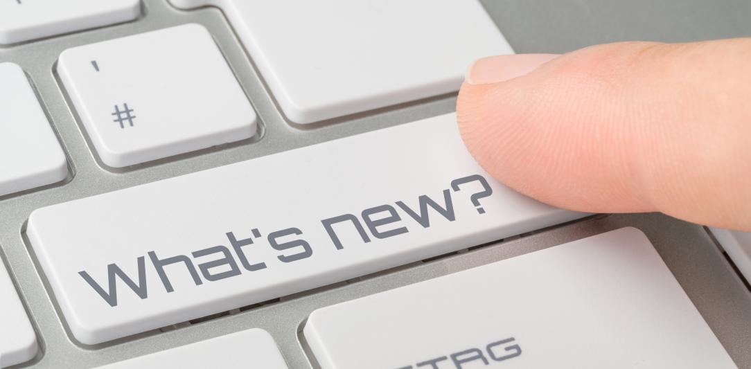 Persoon drukt op toetsenbord met knop 'What's new'