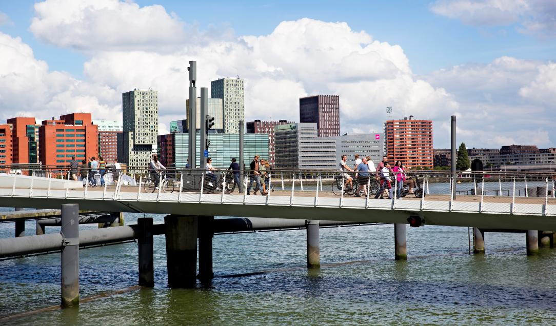 Foto van lopende mensen op een brug in Rotterdam