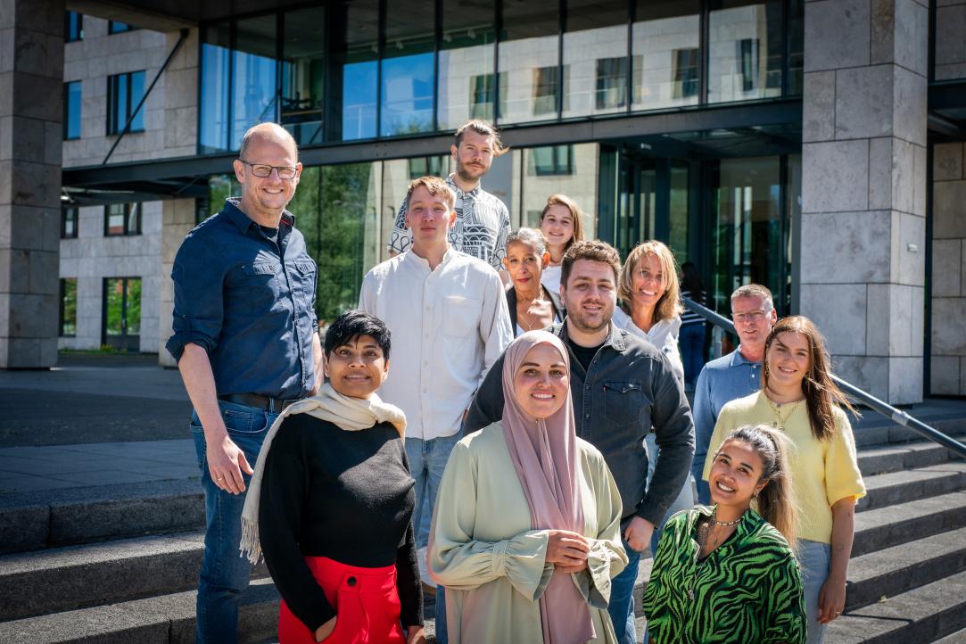 ZonMw-medewerkers staan in een groepje op de trap voor het ZonMw-kantoor