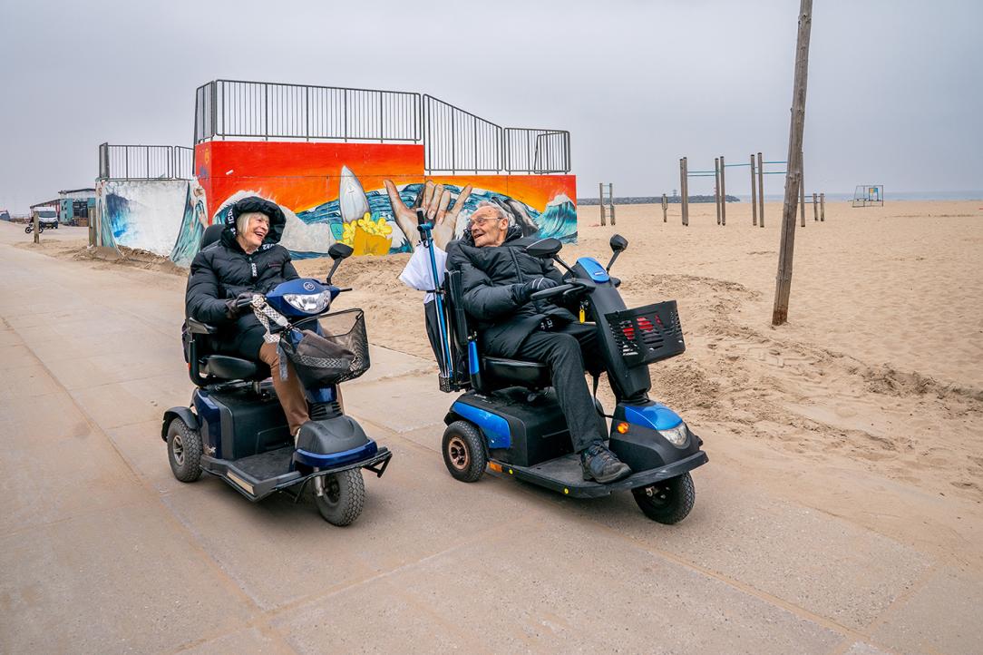 2 senioren in scootmobiels op het strand