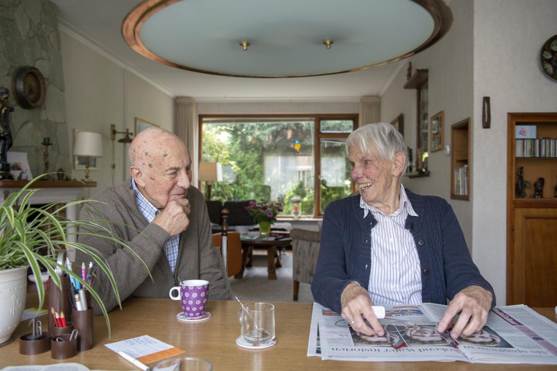Oudere vrouw en man aan keukentafel