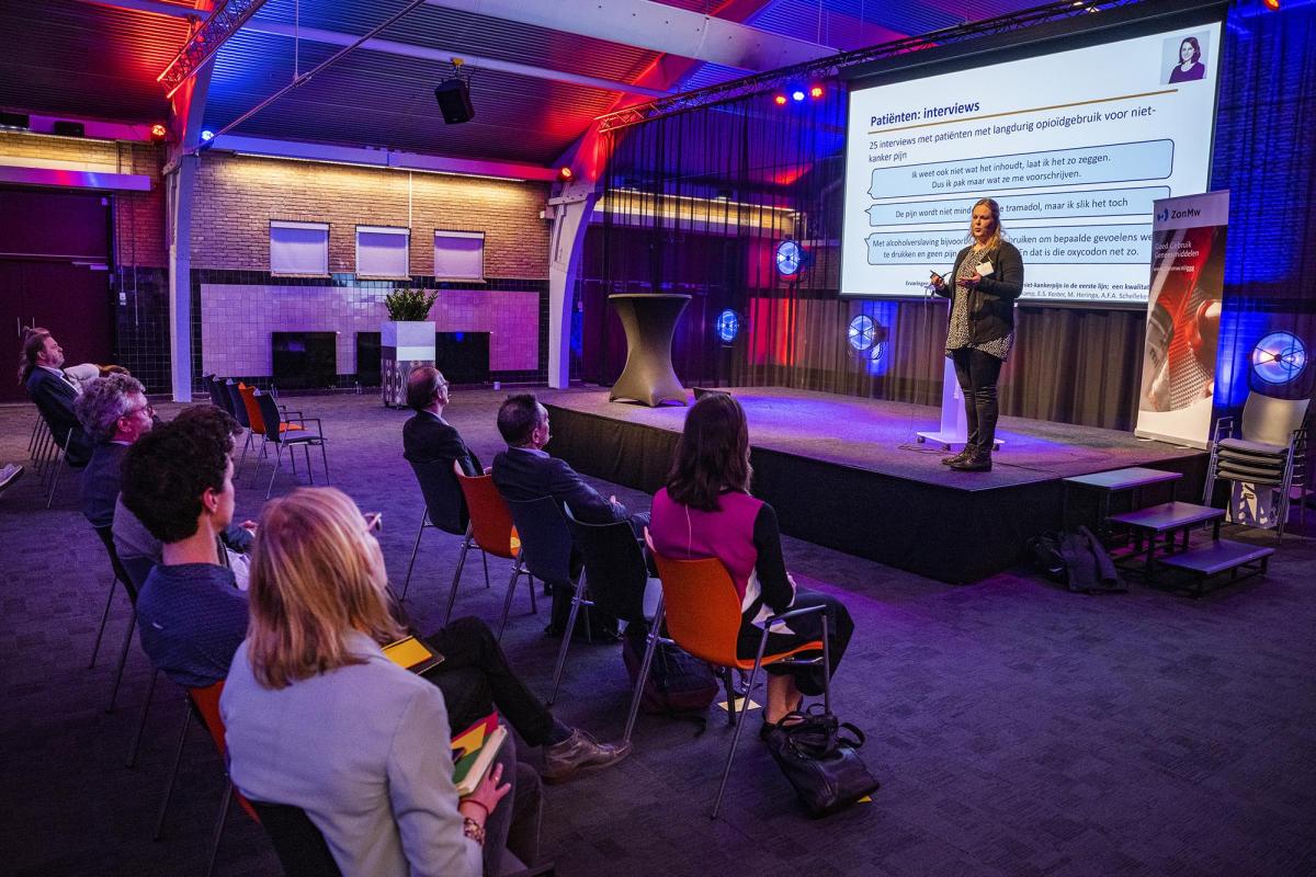 Foto van congres Goed Gebruik Geneesmiddelen: Elsemiek Jansen-Groot Koerkamp over de reductietool TAPTOE: beperken met starten, educatie, een beslisboom, informatie over dosering bij start, verbetering van de overdracht.