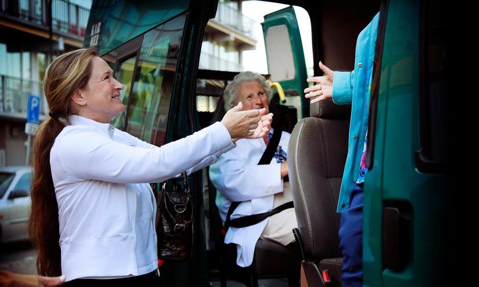 Chauffeur helpt oudere uit bus