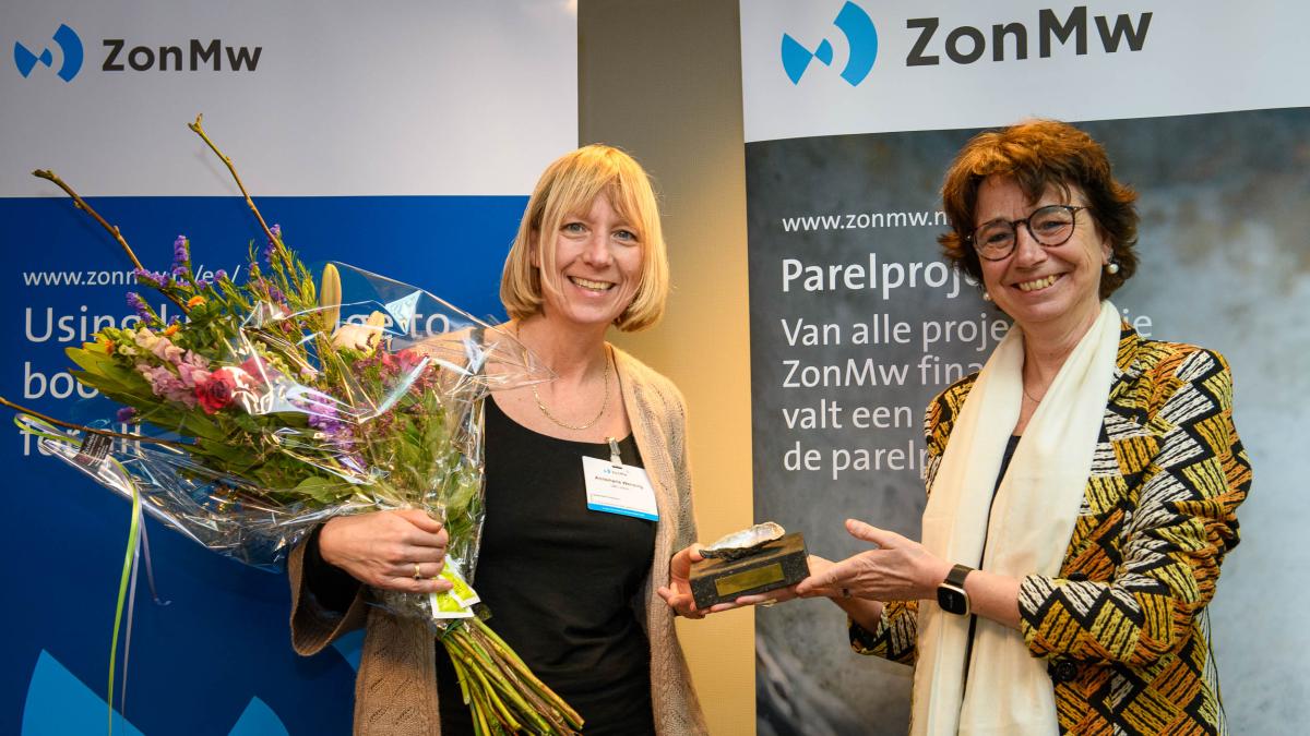 Anne Wensing ontvangt de ZonMw Parel uit handen van Véronique Timmerhuis.
