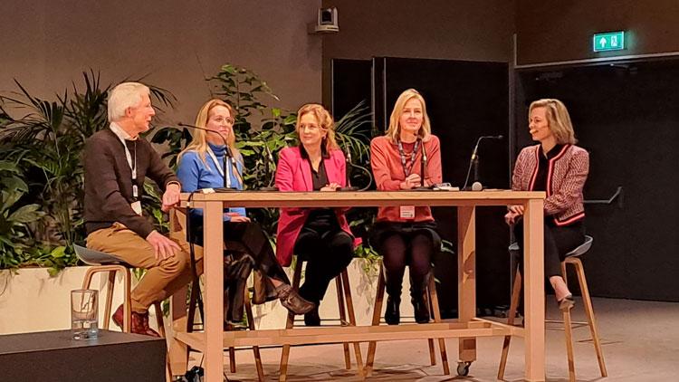 Foto van deelnemers aan het congres tijdens een paneldiscussie