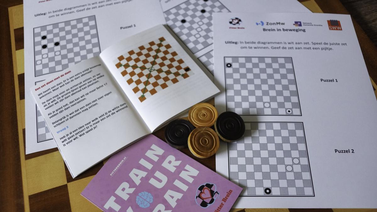 Verschillende damboekjes en dampuzzels liggen op een tafel
