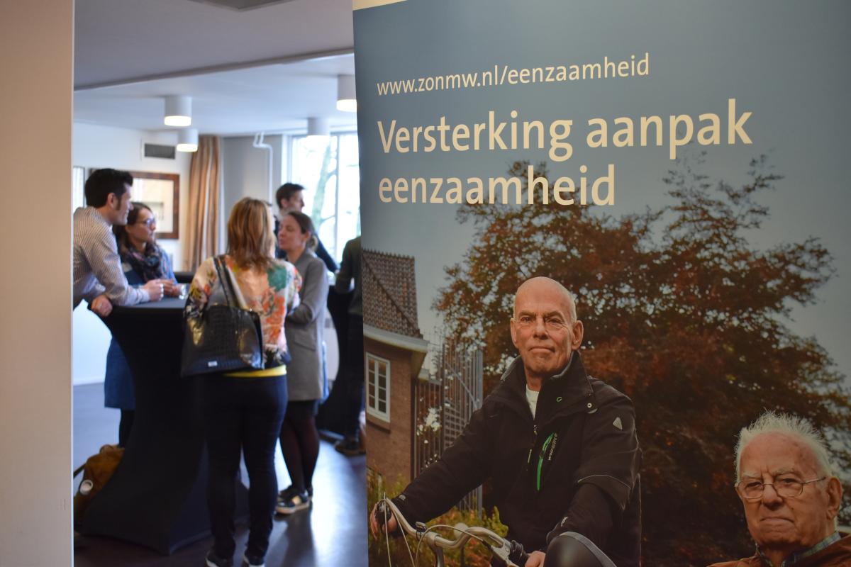 Foto voor de start van de bijeenkomst met banner ZonMw-programma Versterking Aanpak Eenzaamheid