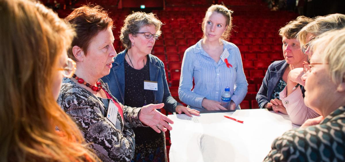 groep mensen discussieert aan statafel in theater
